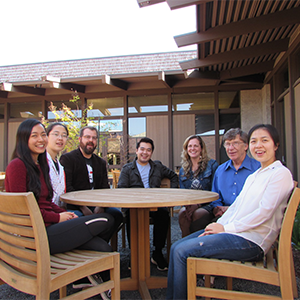 Mike McCusker, Katie Ha, members of the Teaching and Learning Center staff, and students sit in the courtyard of the Teaching and Learning Center