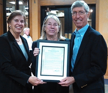 Board of Trustee President, Betsy Bechtel (picture far left) presents a board resolution to Gay and Bill Krause.